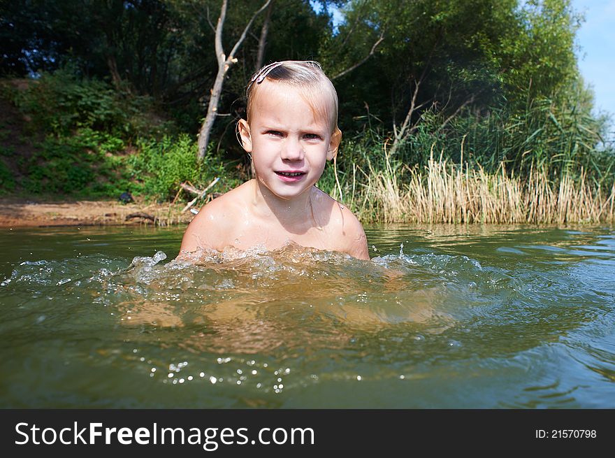 Girl swimming in the lake on a sunny day
