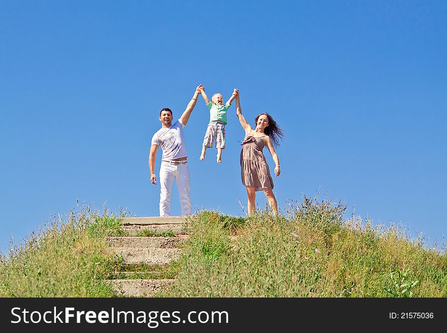 Family under blue sky. Father, mother and son in the park. Family under blue sky. Father, mother and son in the park