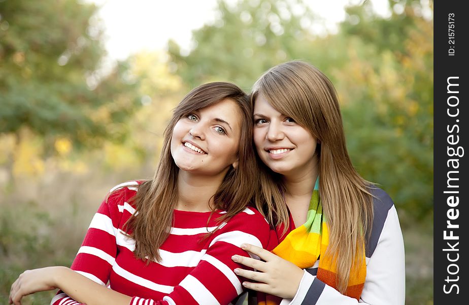 Portrait of redhead and brunette girls at outdoor.