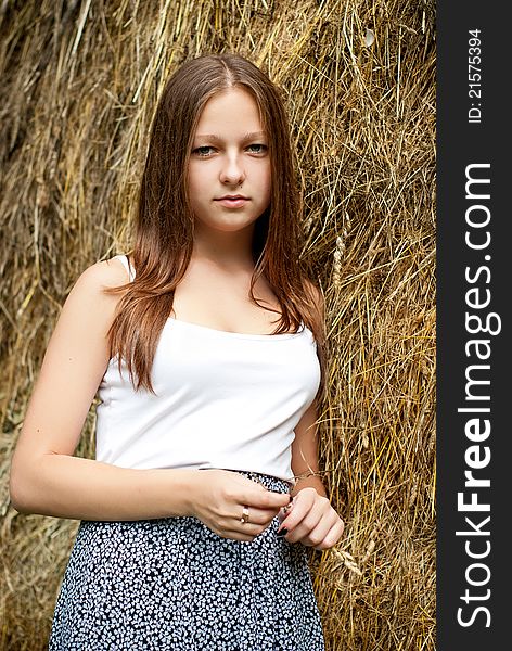 Young woman portrait with hay on background.