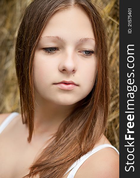 Pretty lady portrait with hay on background.