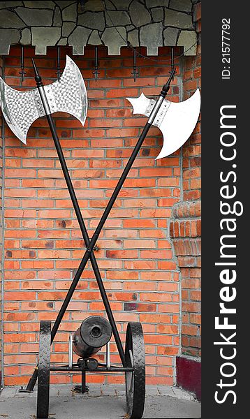Vintage axes and gun on a background of red brick wall