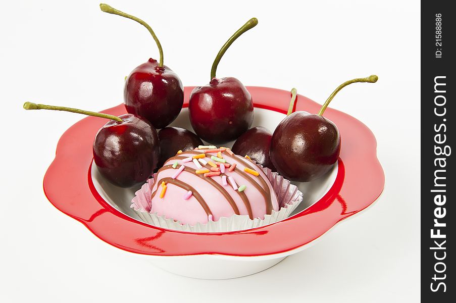 Cup of cake in red bowl with fresh Cherry isolated on white background