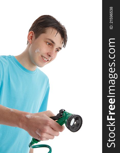A teenage boy using a garden hose and trigger nozzle spray attachmant.