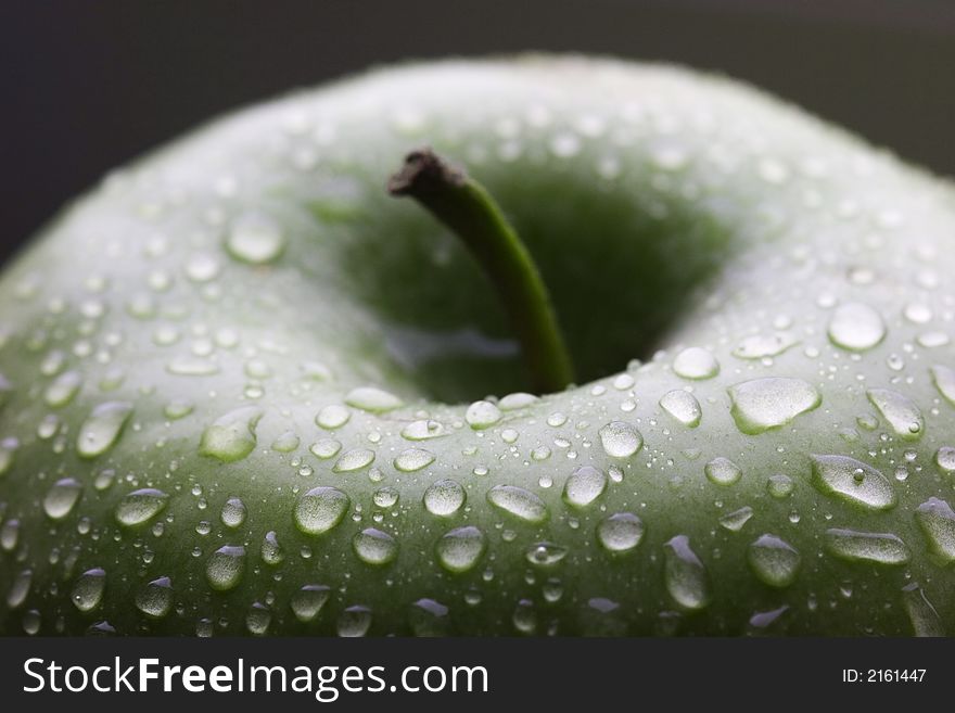 Wet green apple with stem macro