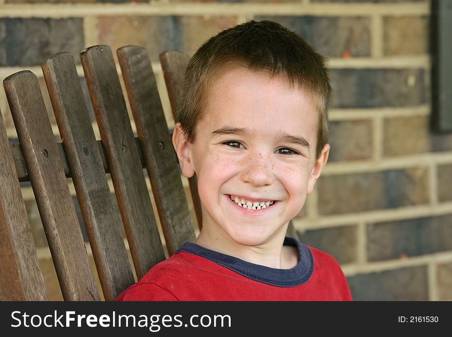 Boy on wood chair with big smile. Boy on wood chair with big smile