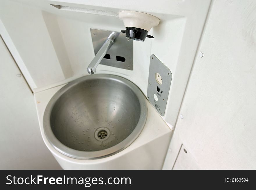 A close up view of a compact sink or hand bowl for washing hands in a restroom of a modern passenger train car. A close up view of a compact sink or hand bowl for washing hands in a restroom of a modern passenger train car.