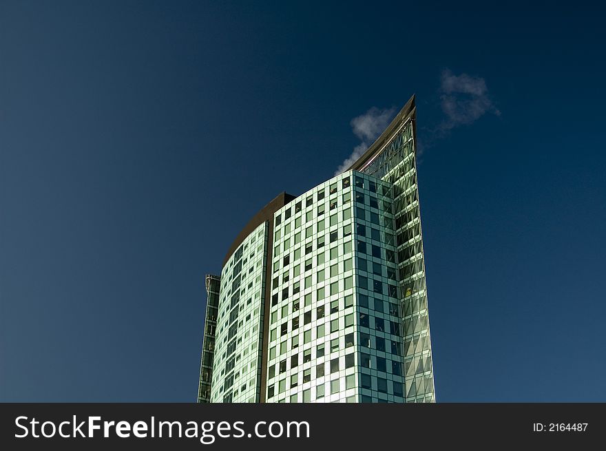 Modern office tower set against a vivid blue sky.