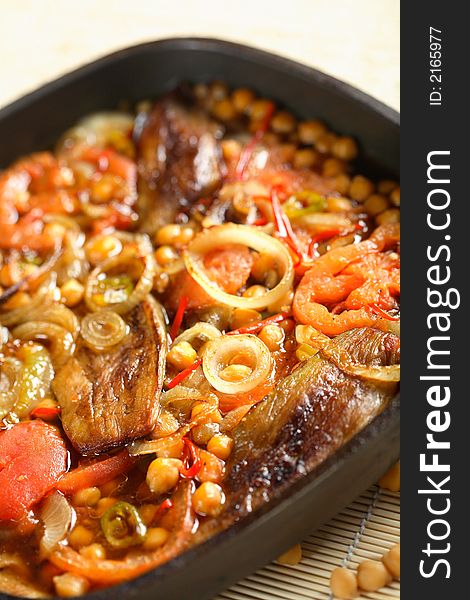 Delicious aubergine with vegetables on the black pan. Delicious aubergine with vegetables on the black pan