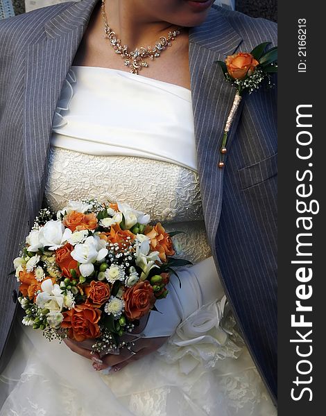 The groom has thrown shoulders her bride with the jacket to warm the young wife in the street after ceremony