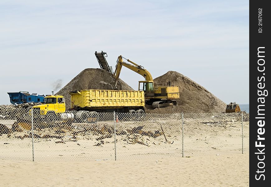 Heavy construction equipment on a work site near a beach. Heavy construction equipment on a work site near a beach.