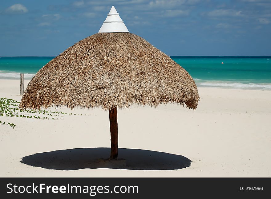 Beautiful Carribbean beach with white sand and wicker umbrella. Beautiful Carribbean beach with white sand and wicker umbrella