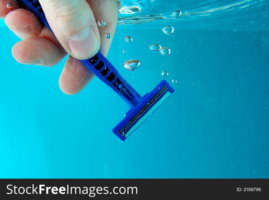 A hand cleaning razor in water. A hand cleaning razor in water