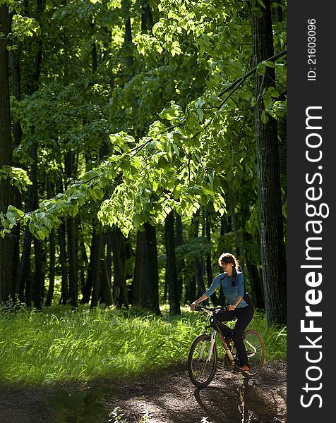 Young woman biking through the forest. Young woman biking through the forest