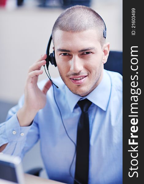 Businessman with a headset portrait at bright call center helpdesk support office