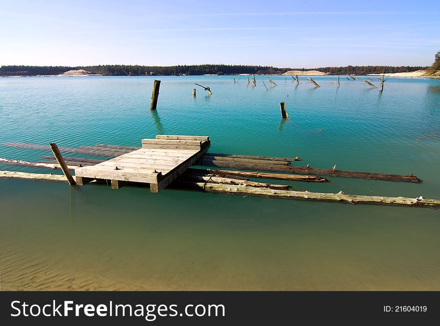 Wooden pier in transparent bright blue lake