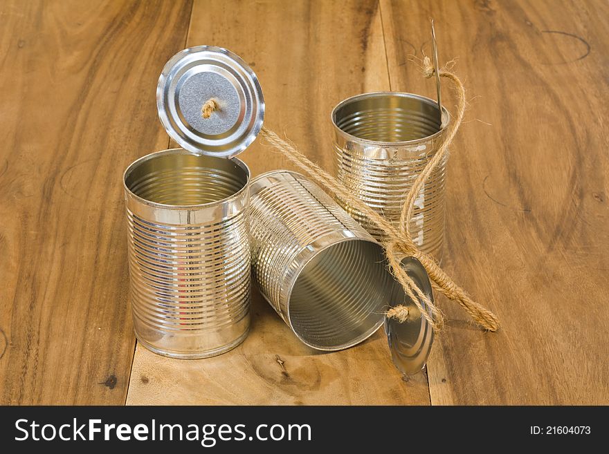 Three open cans on wooden table