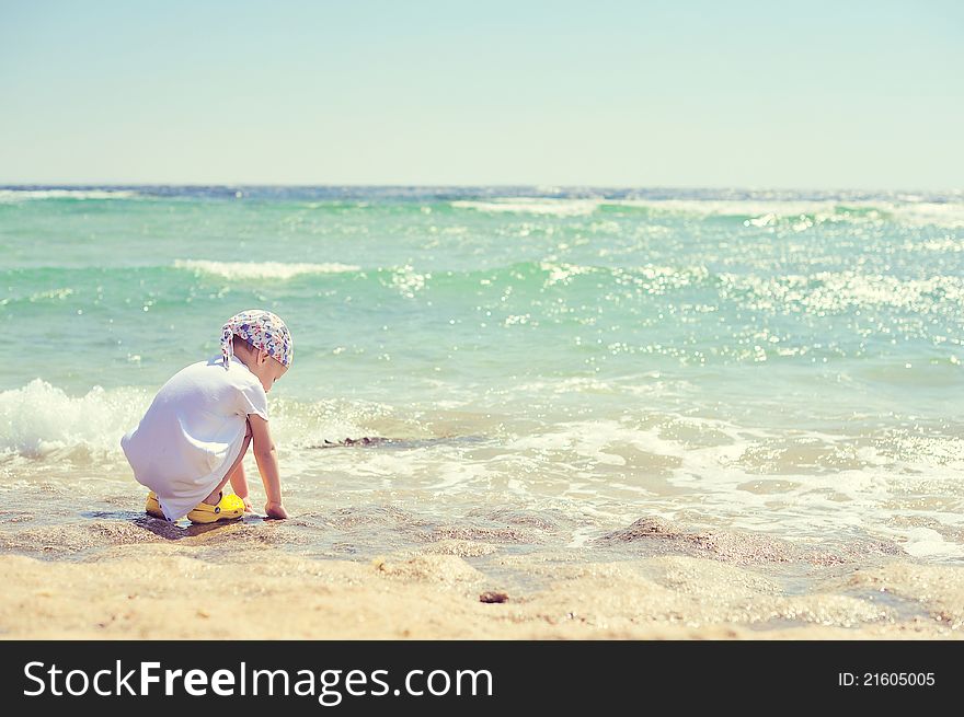 The child on the sea in a hat has a rest in the summer. The child on the sea in a hat has a rest in the summer