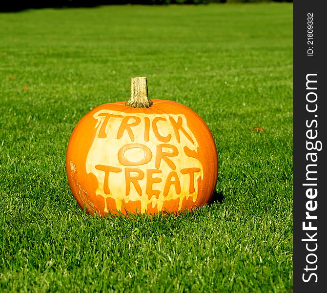 Picture of a pumpkin, with Trick Or Treat cut in the surface. Standing on a lawn. Picture of a pumpkin, with Trick Or Treat cut in the surface. Standing on a lawn