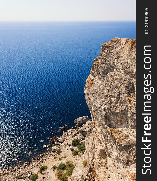 Travel, vacation background - vertical rock, mountain, deep blue sea and beautiful sky. Travel, vacation background - vertical rock, mountain, deep blue sea and beautiful sky