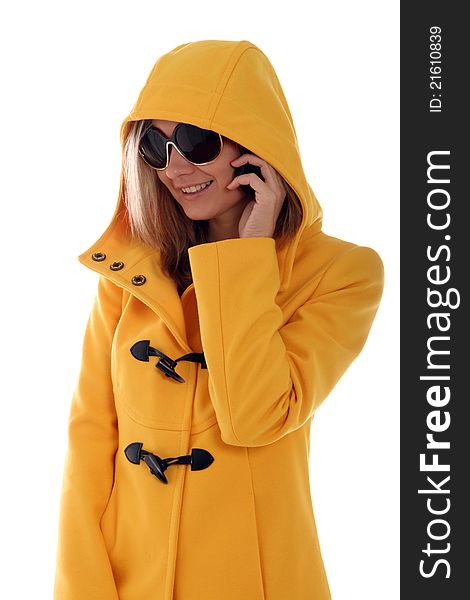 Stylish young lady in yellow hooded jacket on a call. Stylish young lady in yellow hooded jacket on a call