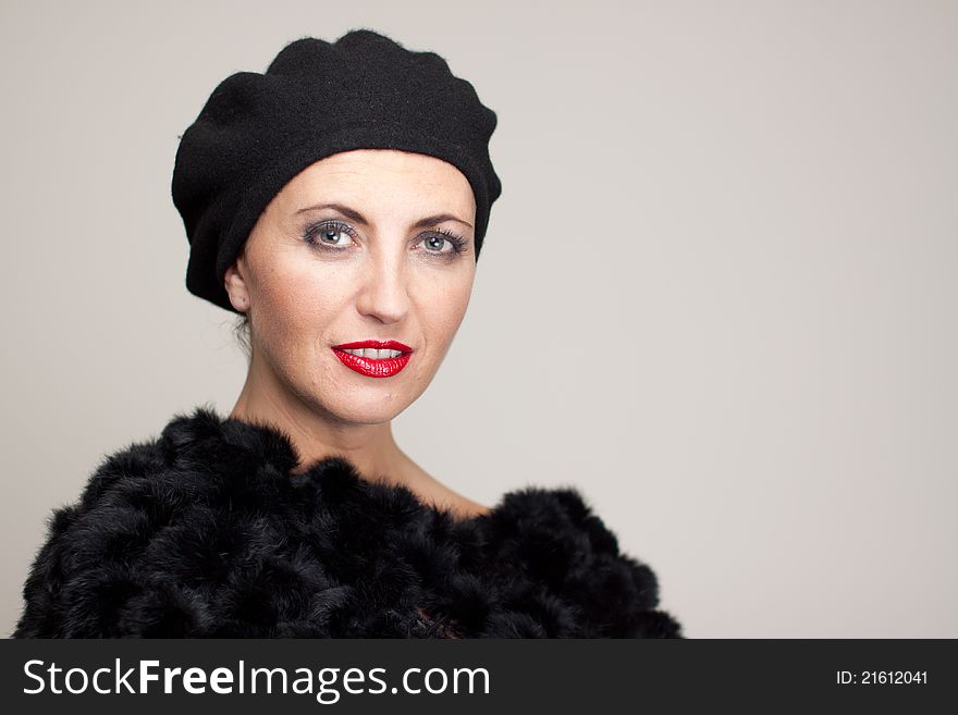 Mature brunette with glamour makeup in black fur, with black beret ,smiling. Mature brunette with glamour makeup in black fur, with black beret ,smiling.