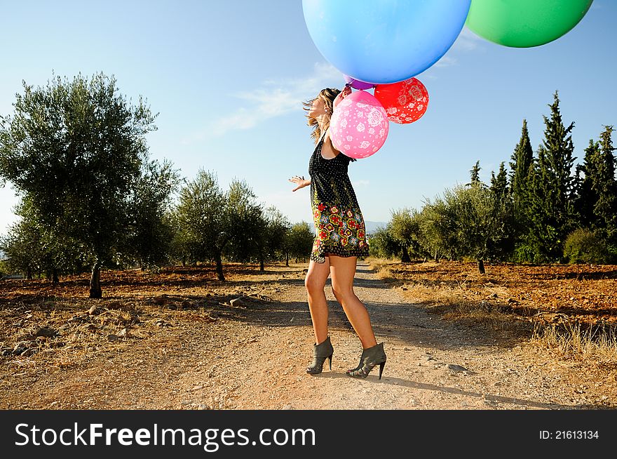Girl with balloons in the field