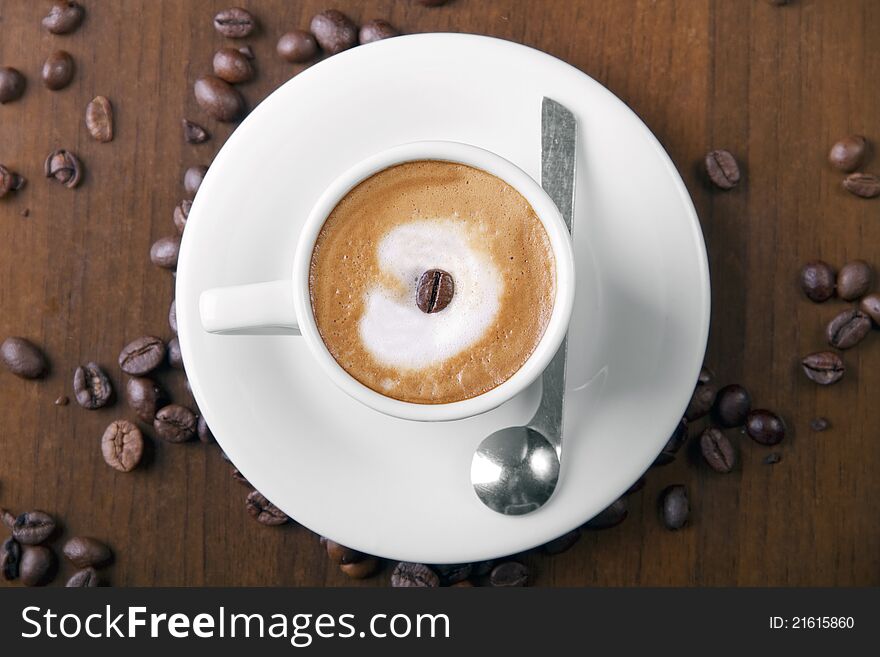 Espresso macchiato in white cup, surrounded with espresso coffee beans. Espresso macchiato in white cup, surrounded with espresso coffee beans