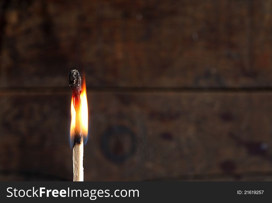 Closeup of one burning match on dark background