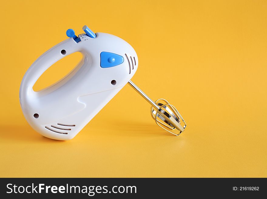 A new white electric mixer on yellow background with free space for text
