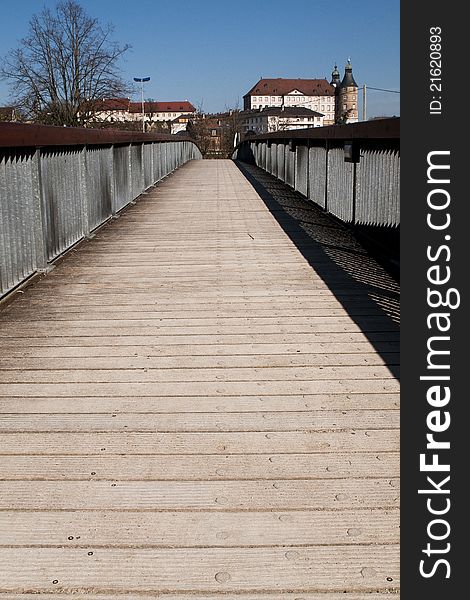 Footbridge in the city of Montbeliard, France. In the background, the famous castle of Montbeliard. Footbridge in the city of Montbeliard, France. In the background, the famous castle of Montbeliard.