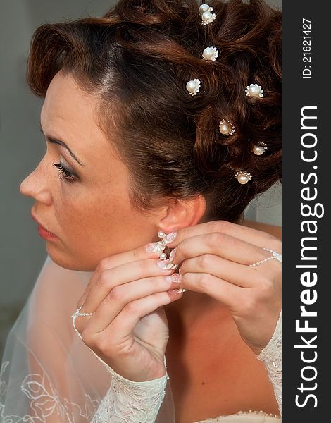 Image of a beautiful bride adjusting her earring