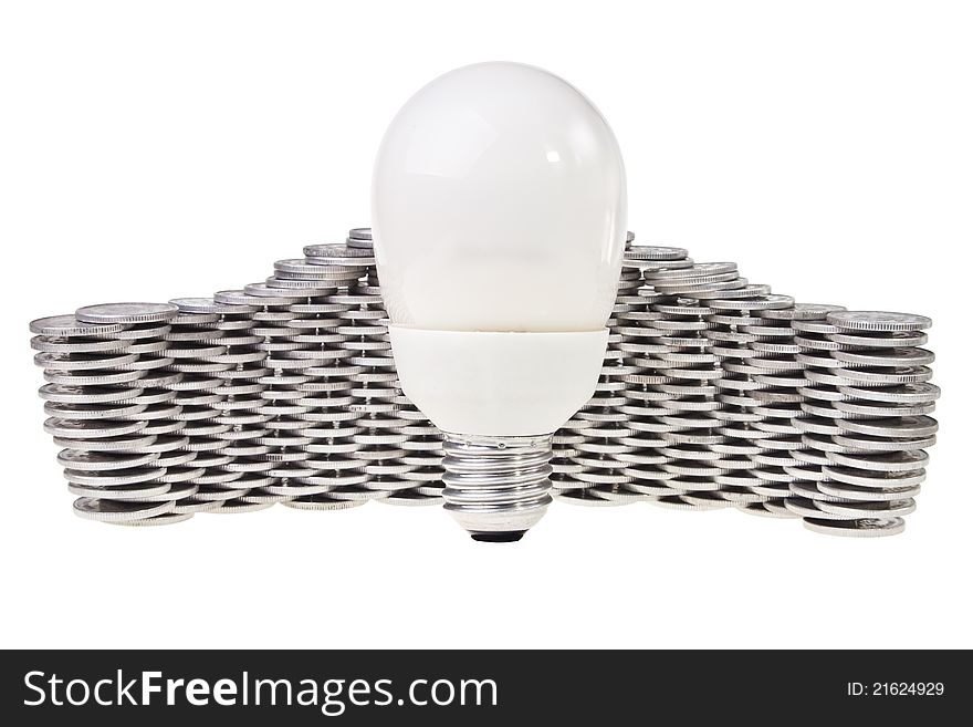 Power saving energy lightbulb with stacked silver coins behind over white background. Power saving energy lightbulb with stacked silver coins behind over white background.