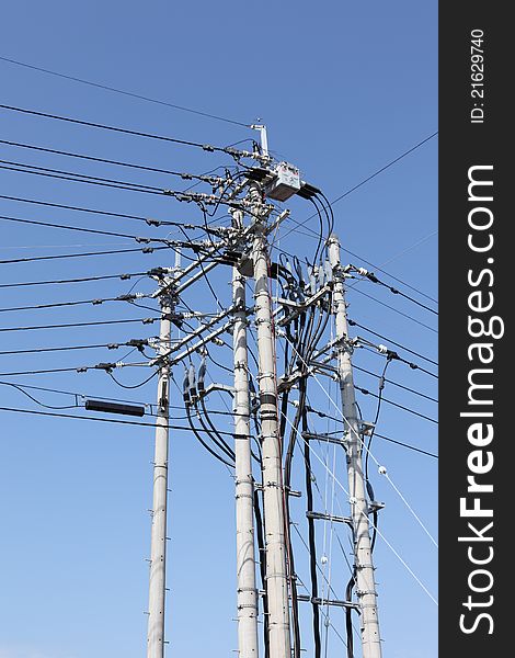 Electrical post with power lines against blue sky. Electrical post with power lines against blue sky