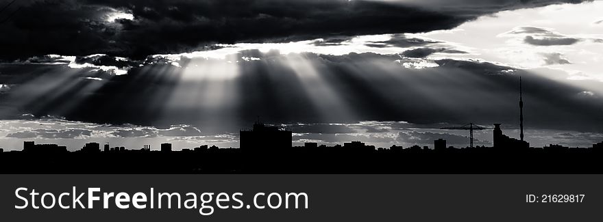 Black and white dramatic cloudscape with rays of light piercing through the clouds. Black and white dramatic cloudscape with rays of light piercing through the clouds.