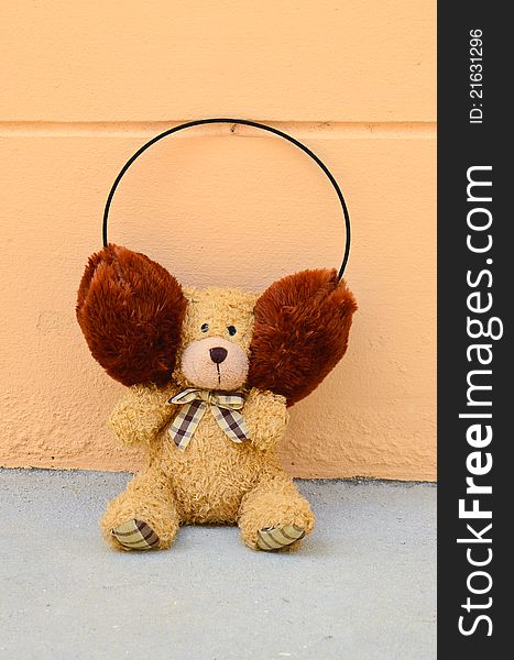 Teddy Bear with plaid bow on wall orange background