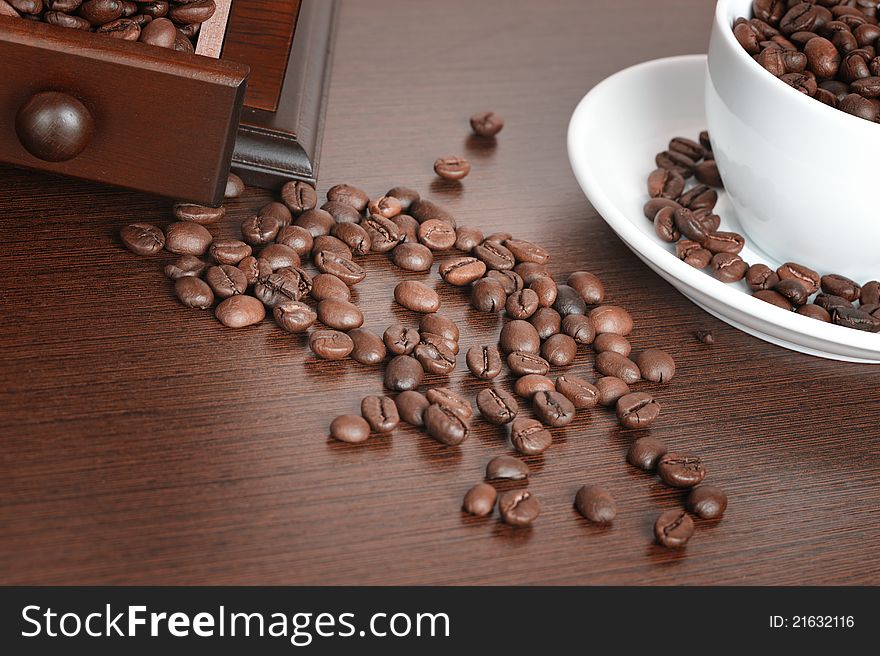 Coffee beans and old coffee mill on the table