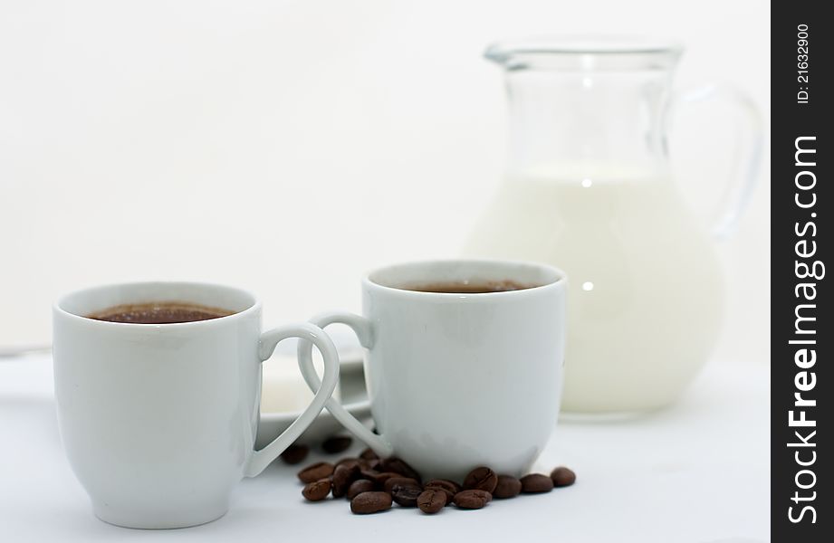 Two espresso cups with coffee over white background