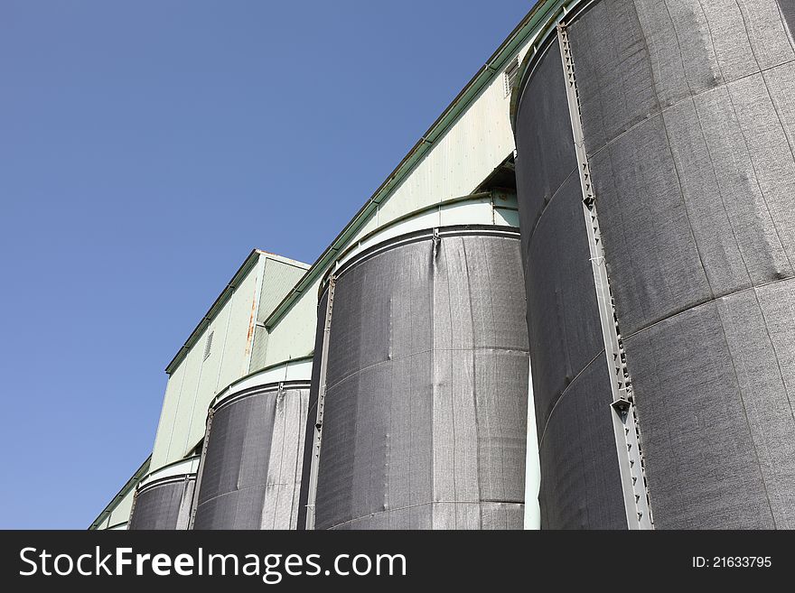 Photograph of industrial storage silo and blue sky