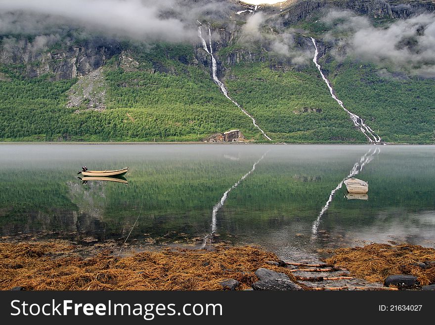 A fjord scenic, smooth surface reflection of mountains, two boats. Norway. A fjord scenic, smooth surface reflection of mountains, two boats. Norway.