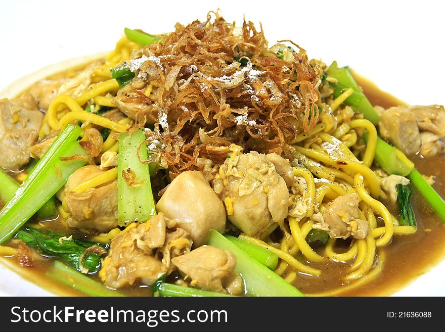 Egg noodle stir fried with chicken and bok-choy on top with crispy shallot