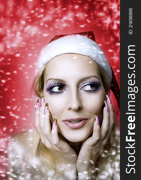 Christmas bright make-up and long nails manicure concept. Portrait of young woman model at santa hat, face closeup. Christmas bright make-up and long nails manicure concept. Portrait of young woman model at santa hat, face closeup