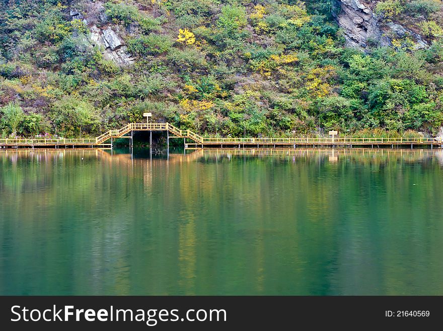 Wooden bridge with plank road reflection in lake