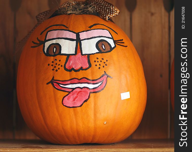 Halloween jackÃ¢â‚¬â„¢o lantern with a cute face painted on it, against a wooden background. Halloween jackÃ¢â‚¬â„¢o lantern with a cute face painted on it, against a wooden background.