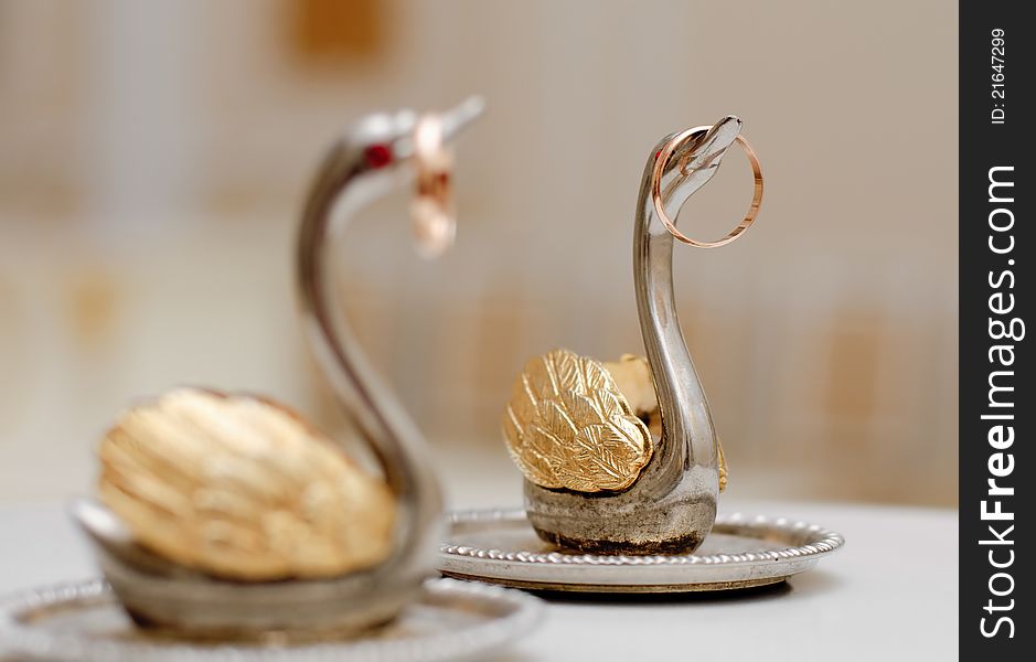 Two gold wedding rings on beautiful swans