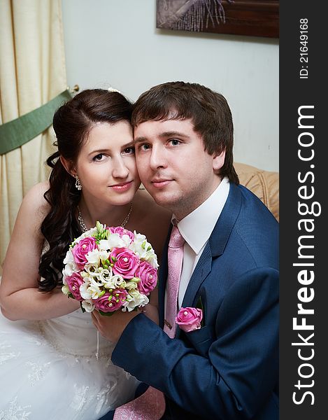 Happy bride and groom in interior on wedding day