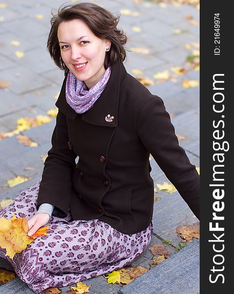 Lovely smiling woman with autumn leaves