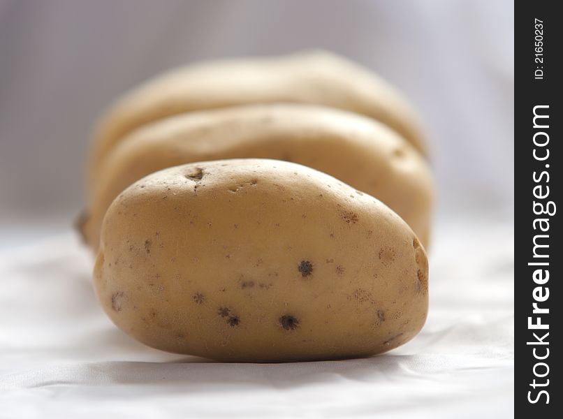 Bunch of potatoes on white background close up shoot