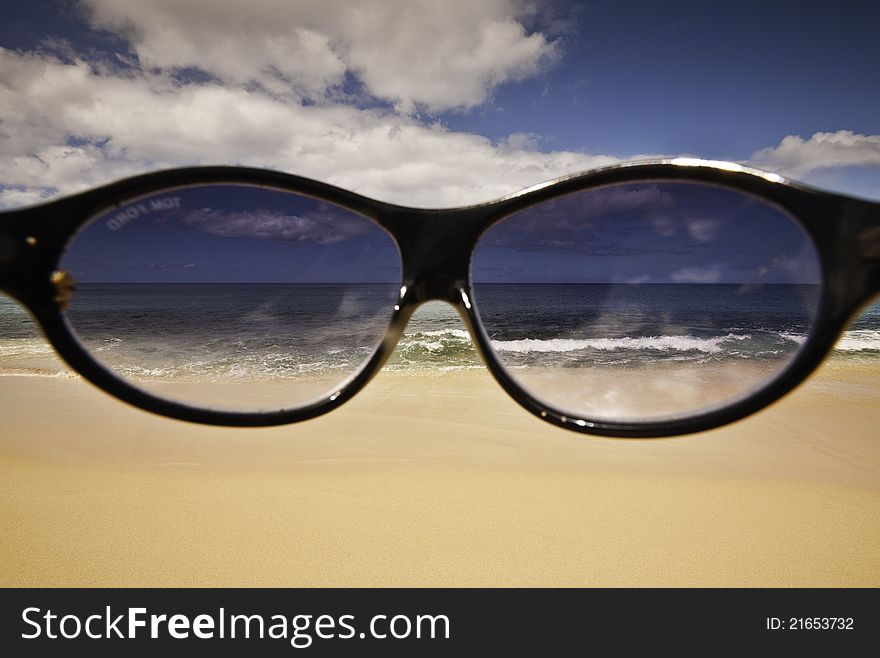 Shades in front of the camera on a bright day on a pristine Hawaiian beach. Shades in front of the camera on a bright day on a pristine Hawaiian beach.