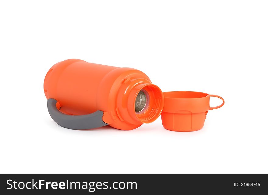 Empty modern orange thermos lying near mug on white background. Isolated with clipping path. Empty modern orange thermos lying near mug on white background. Isolated with clipping path